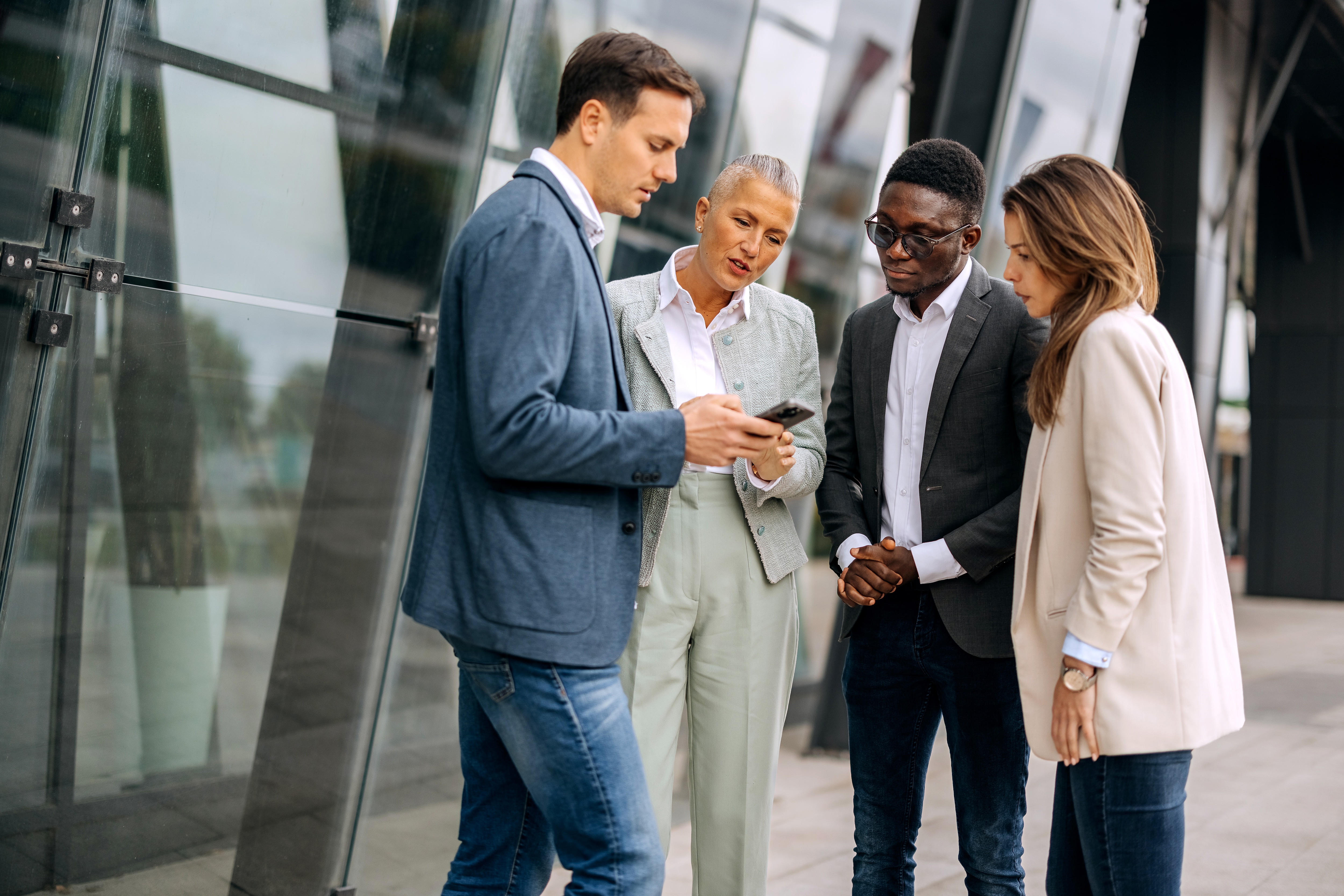 A group of coworkers looking at a cellphone