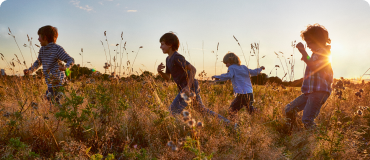Four children running in a field