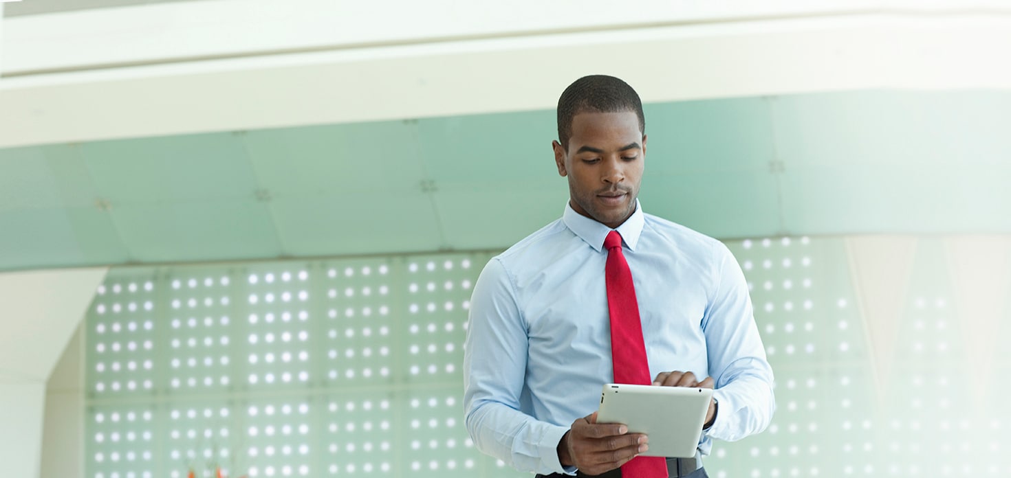 A businessman in a red tie using a tablet