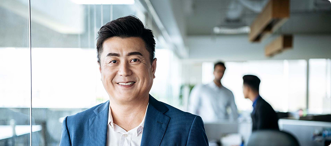Man standing and smiling at the camera in an office