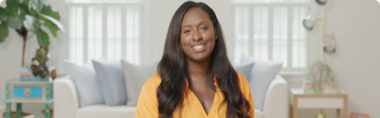 Young African American woman smiling at the camera sitting on a white couch