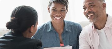 A man and a woman smiling at a woman in front of them