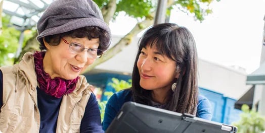 An older woman and middle aged woman looking at a laptop