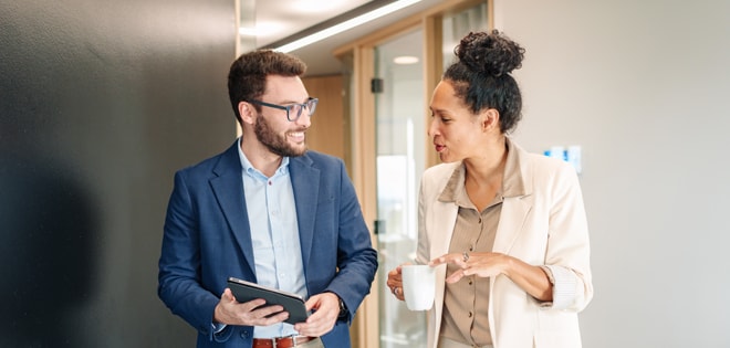 man and woman walking down an office hallway