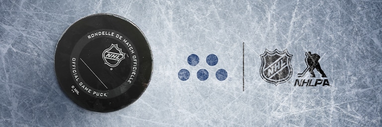 Close up of Hockey Puck on the rink next to the MassMutual , NHL and NHLPA logos