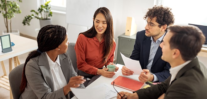 Two businessmen and two businesswomen meeting in an office.